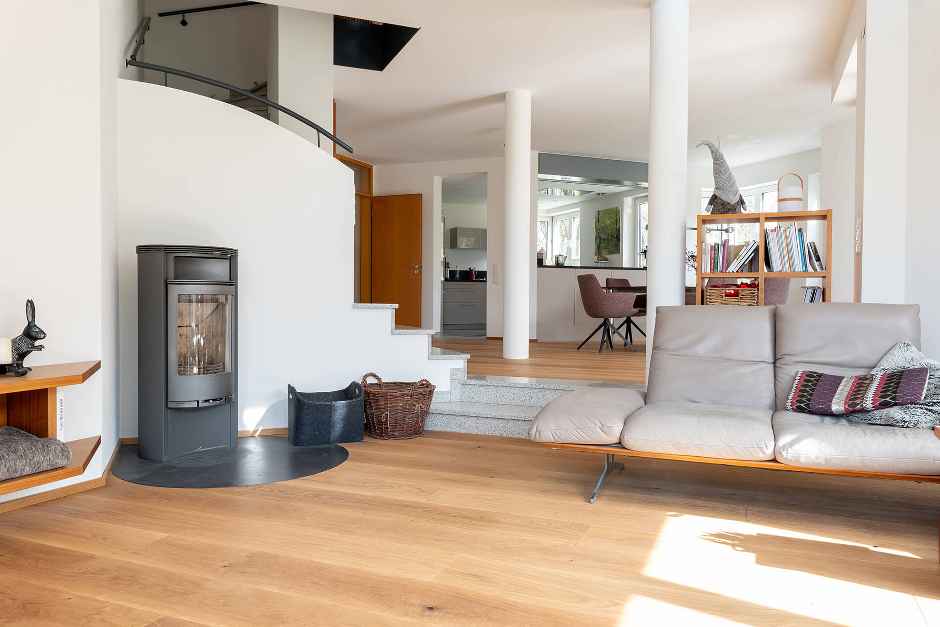 referenz-landhausdiele-boston-eiche-xl-astig-geölt-2 gemütliches Wohnzimmer mit breiter Landhausdiele, Kachelofen und Sofa