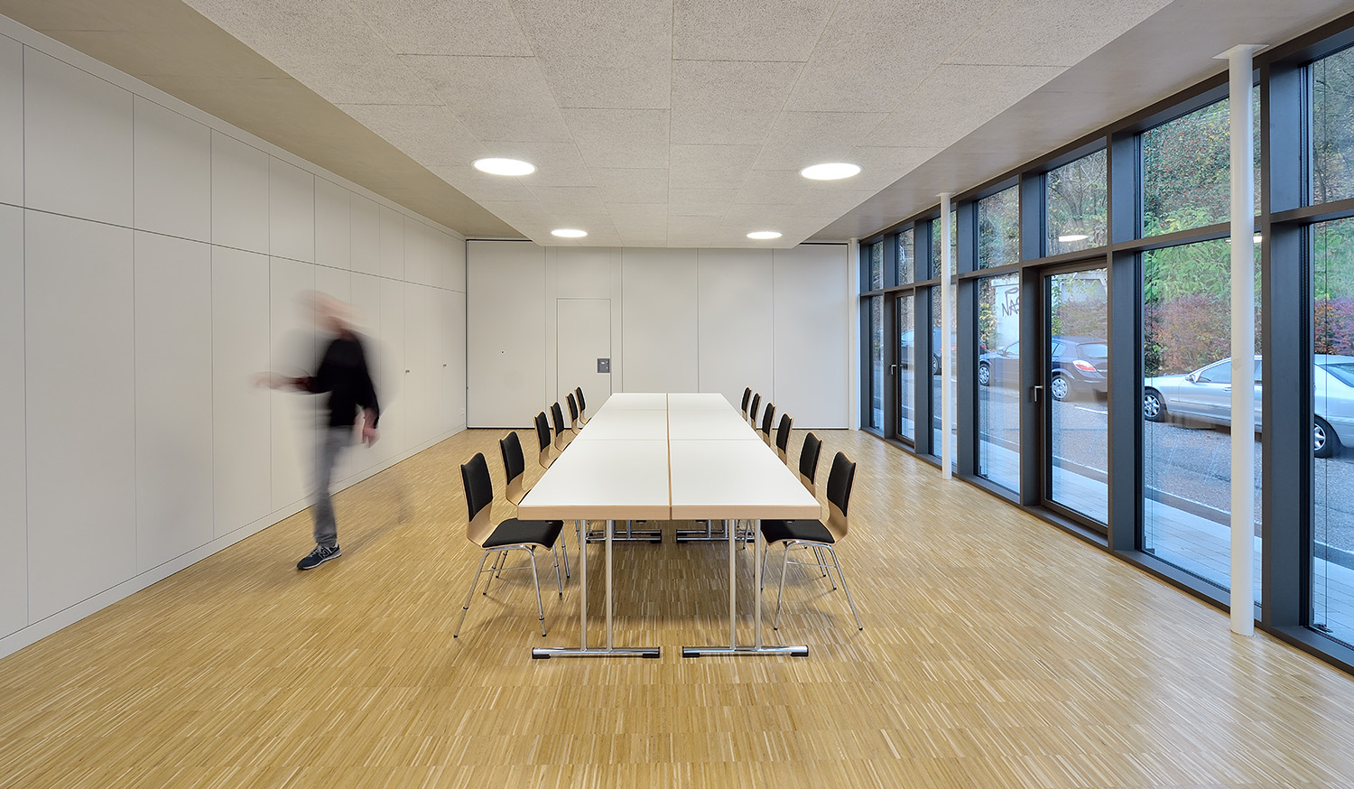 Stabilo Hochkantlamelle Eiche Versiegelt – Funktionalität und Langlebigkeit Moderner Besprechungsraum mit großen Fensterfronten, weißem Mobiliar und robustem Stabilo Hochkantlamellen-Parkett in Eiche versiegelt